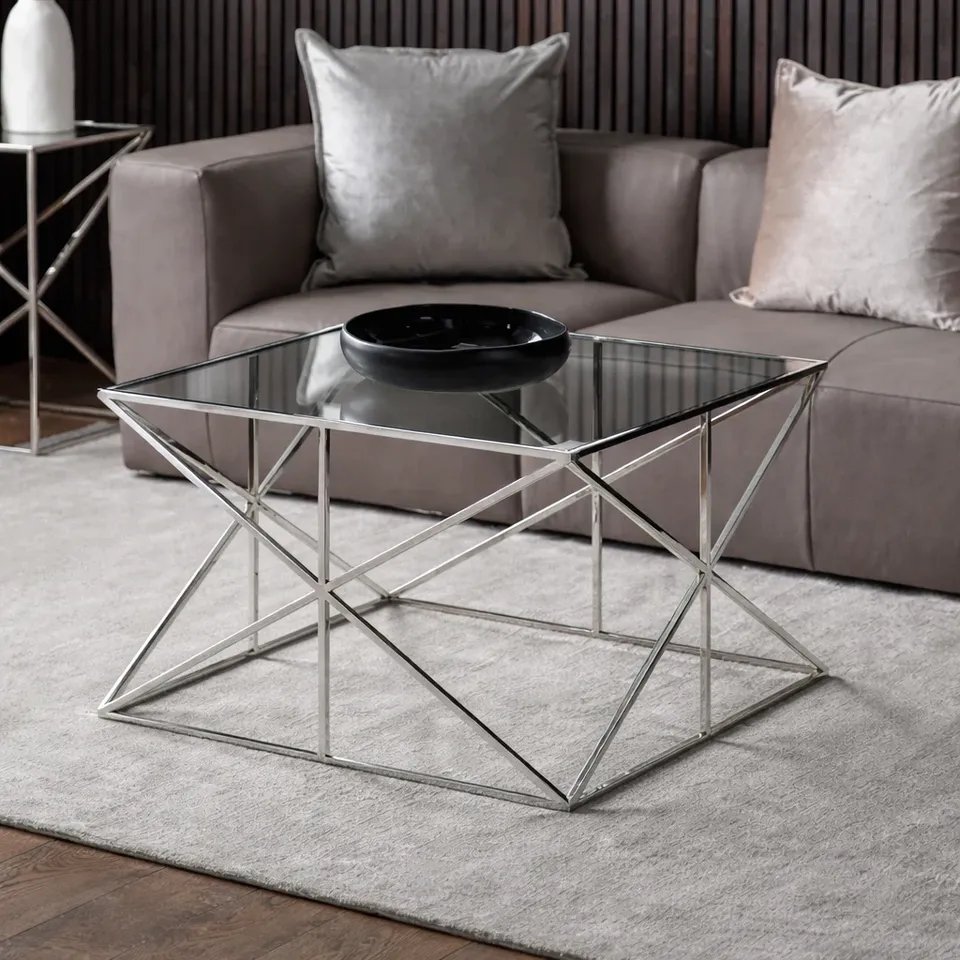 Gallery Direct Parma coffee table with smoked glass top and polished steel frame in front of a taupe sofa